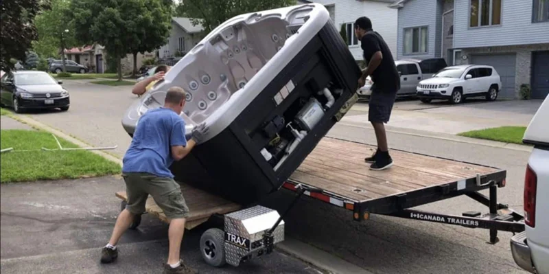 Hot tub being positioned on transport equipment